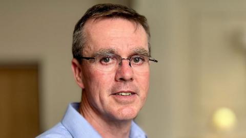 Portrait of Dr Stephen Brearey, wearing glasses and a blue shirt, looking directly at the camera