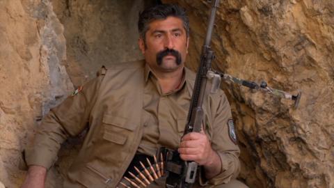 A Kurdish Pershmerga fighter in a cave with a gun