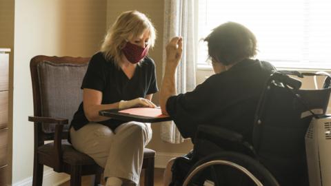 Care worker in mask and gloves