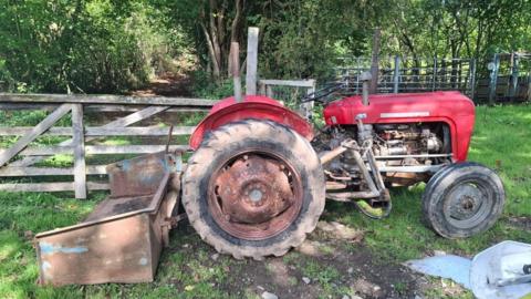 Tractor yn cael ei ddefnyddio i rwystro giât