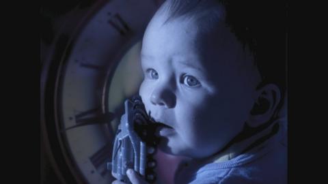 Baby with clock behind