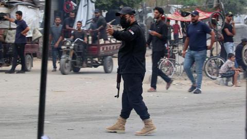 An armed member of the internal security forces loyal to Hamas directs traffic in the central Gaza Strip. Photo: 12 October 2025