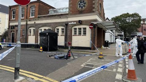 An area of a town centre is cordoned off with police tape. 