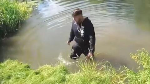 Man wading in a river.