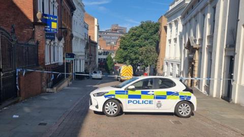 Police cordon and police car in Hounds Gate, in Nottingham
