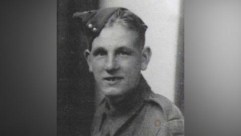 Grainy black and white image of Pvt Clayton looking at the camera. He is wearing his army uniform. 