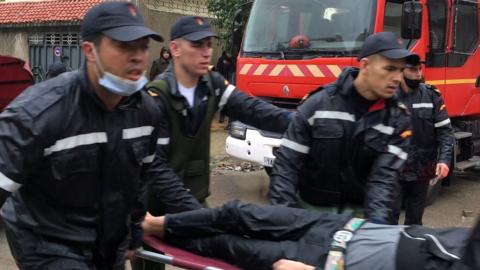 Rescue workers carry a person on a stretcher at the site of the flood