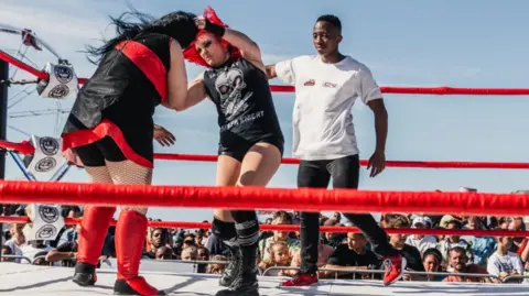 Saraya Knight (centre) beat home fighter Rene Koen (left) aka 'Black Widow) at WrestleMonster 6 in South Africa in March