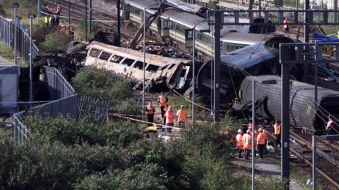 Investigators inspect the wreck of the two mainline trains which collided 05 October 1999 at the peak rush hour near London's Paddington station