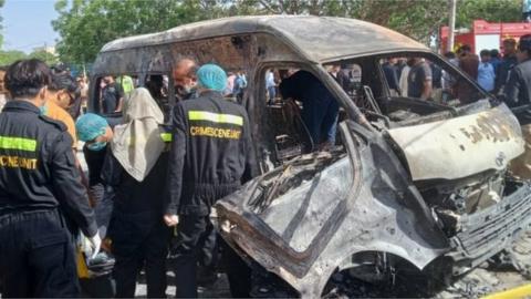 Pakistani security officials inspect the scene of an explosion in Karachi, Pakistan, 26 April 2022.