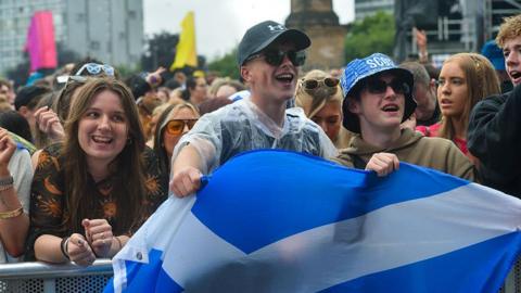 Fans hold a saltire at the barrier for TRNSMT music festival