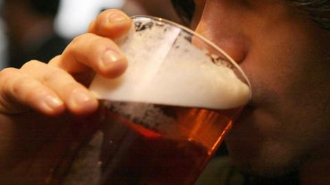 Close up of unknown man drinking a pint of beer