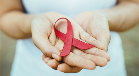 a small red ribbon in a hand