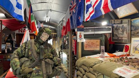 World War Two flags, weapons, sandbags, uniforms