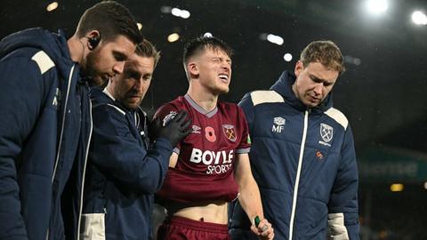 West Ham's Oli Scarf leaves the pitch with an injury as physios try to help him