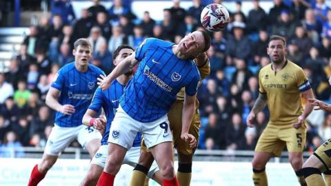 Portsmouth's Colby Bishop heading the ball during their game against QPR