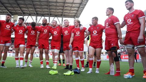 Wales players in a huddle after defeat against Japan