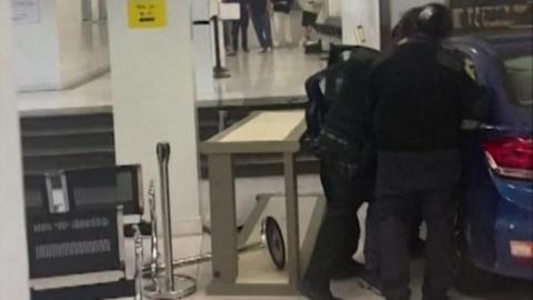 Security staff stand near car in the consulate