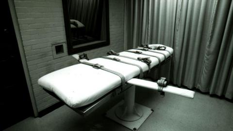 A bed with straps on it in an execution chamber