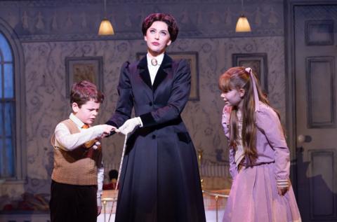 An actress playing Mary Poppins at the Bristol Hippodrome looks exasperated as two children, a girl and a boy, stand each side of her