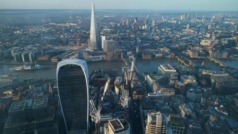 London skyline shows City of London skyscrapers and the Shard either side of the Thames