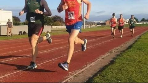 Runners racing on an athletics track