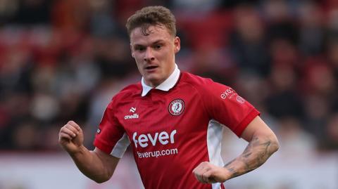 Bristol City defender Cameron Pring in action wearing the Championship team's home colours of red and white.