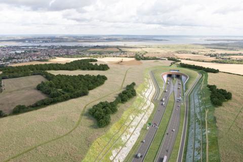 A duel carriageway road leading into and out of a tunnel surrounded by green countryside 