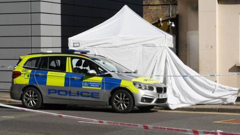 Met Police car parked outside forensics tent