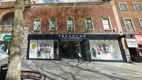 Google street view of the shop front- with a black and white Peacocks signboard.