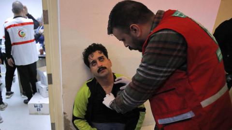 An injured football fan receives treatment after a crush outside the Basra International Stadium in Basra, Iraq (19 January 2023)