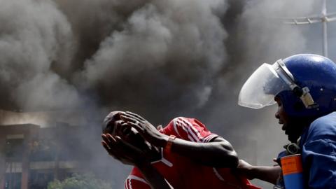 Adetained protester cries in front of a burning barricade during a protest against President Pierre Nkurunziza"s decision to run for a third term in Bujumbura, Burundi May 13, 2015.