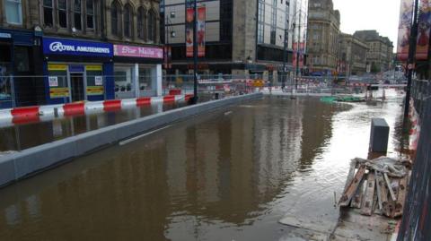 Water from a burst main covering a section Bridge Street in Bradford city centre. 