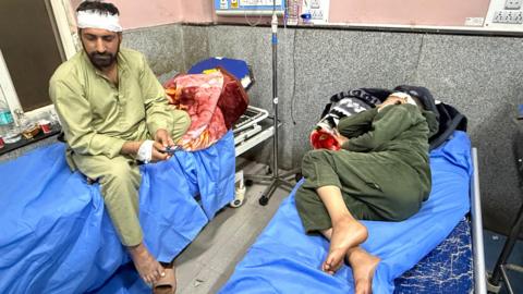 Badrudin and a woman lying in a hospital bed