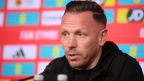 Craig Bellamy speaks at a news conference