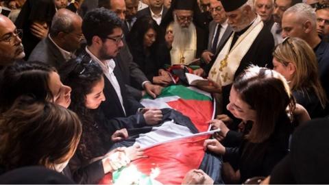 Mourners surround the coffin of killed journalist Shireen Abu Aqla