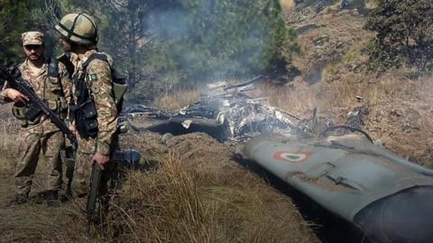 Pakistani soldiers near what appears to be aircraft wreckage