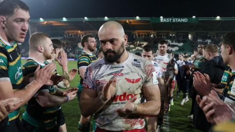Scarlets captain Josh Macleod is applauded off the field by Northampton Saints players