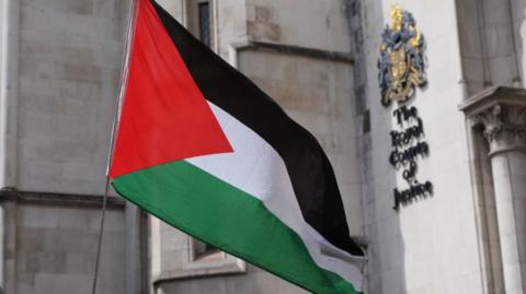 Palestinian flag is held aloft outside courts of justice in London