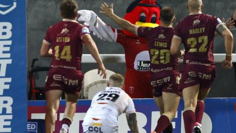 Mikey Lewis (centre) celebrates his try