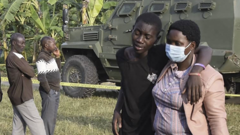 A boy is comforted at the scene of an attack in Mpondwe, Uganda on 17 June 2023