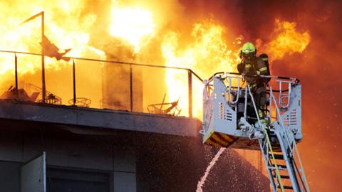 A firefighter works at the scene during the building fire in Valencia