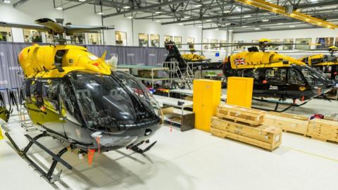 Several yellow airports lined up in a hangar.