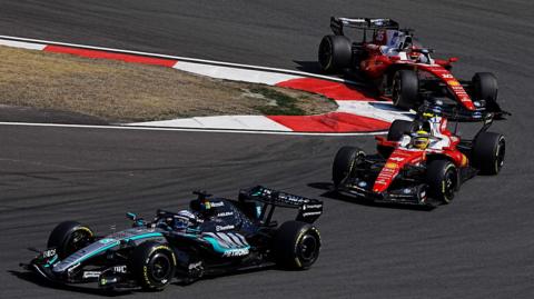 Mercedes' George Russell comes out of a hairpin ahead of Ferrari's Lewis Hamilton with Charles Leclerc immediately behind during the Chinese Grand Prix sprint race