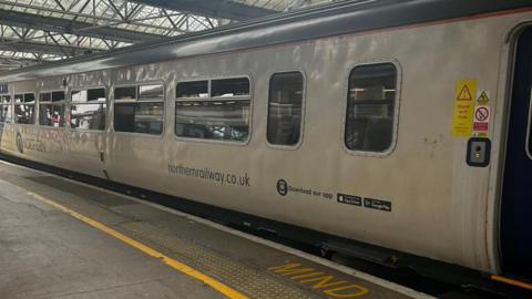 A Northern Railway train at a train platform.