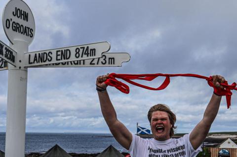 Marcus completing the run at John O'Groats 