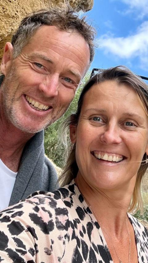 A man and a woman smiling at the camera