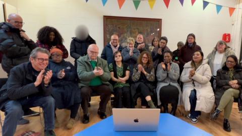Members of the Blackbird Leys choir watch a video clip