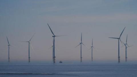 Several wind turbines in the blue sea, with a grey-blue sky