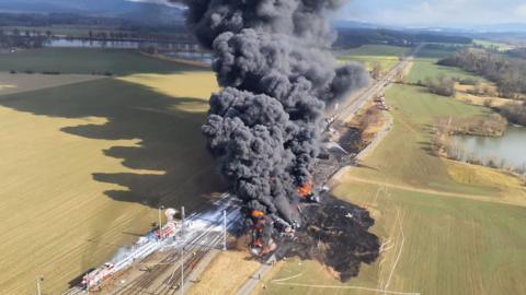 A drone shot showing huge plumes of smoke from a massive train fire